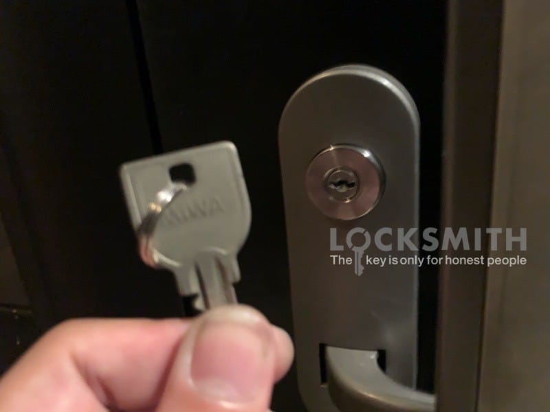 扉の前で鍵をもっている