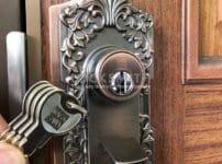 鍵交換完了。シリンダーの前で付属の鍵を数本持っている