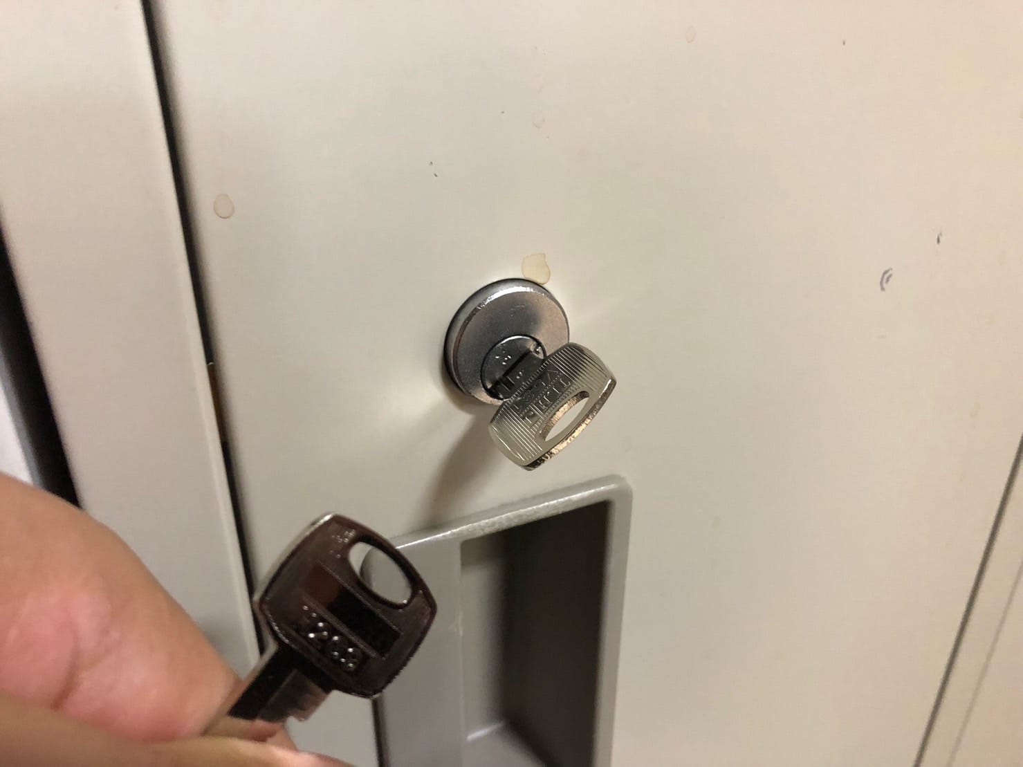 作製した鍵２本。１本は鍵穴にささっていてもう１本は手に持っている