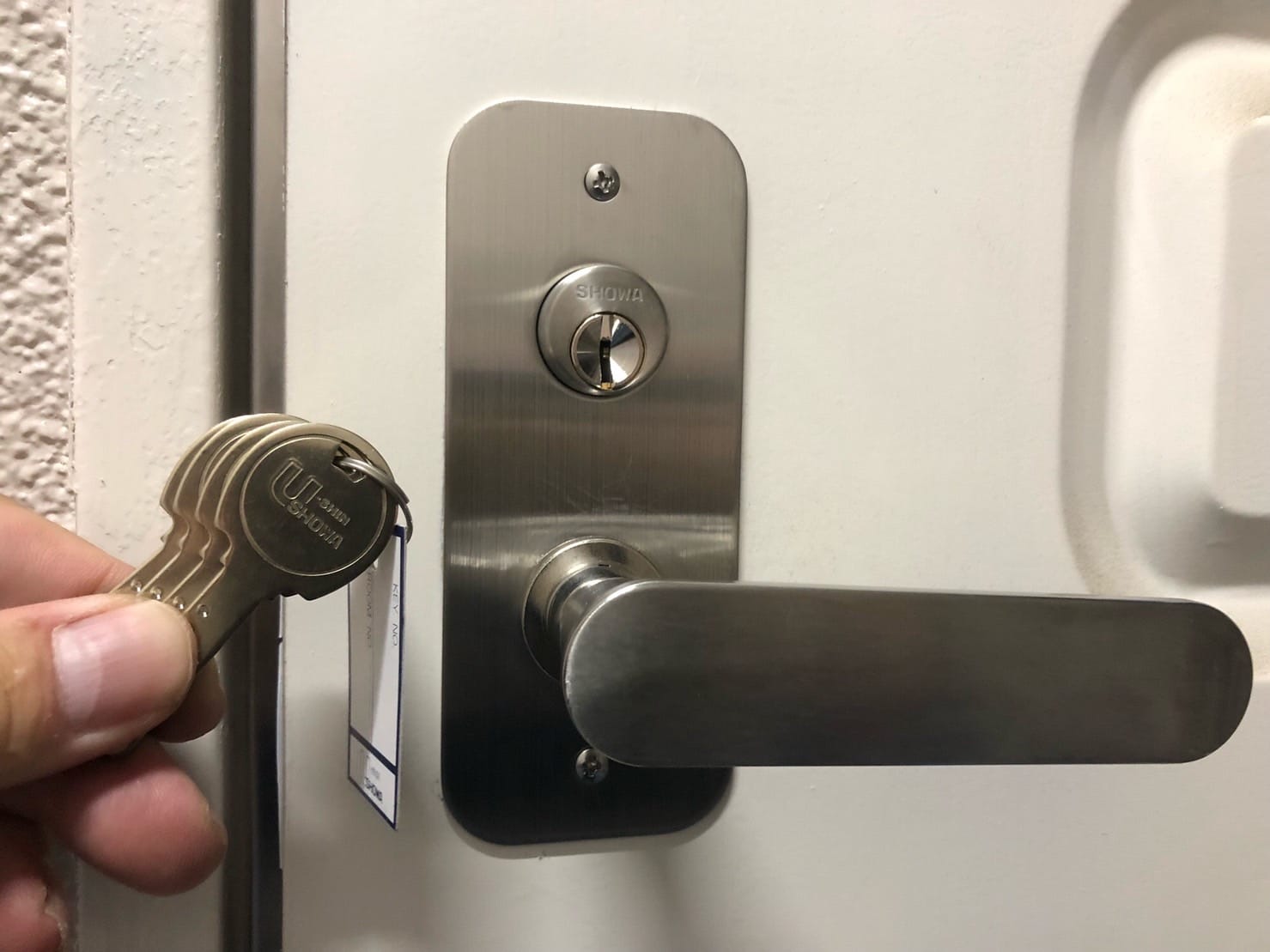 鍵交換完了。新たなレバーハンドルと面付錠が扉につきました。付属の鍵扉の傍でもっている