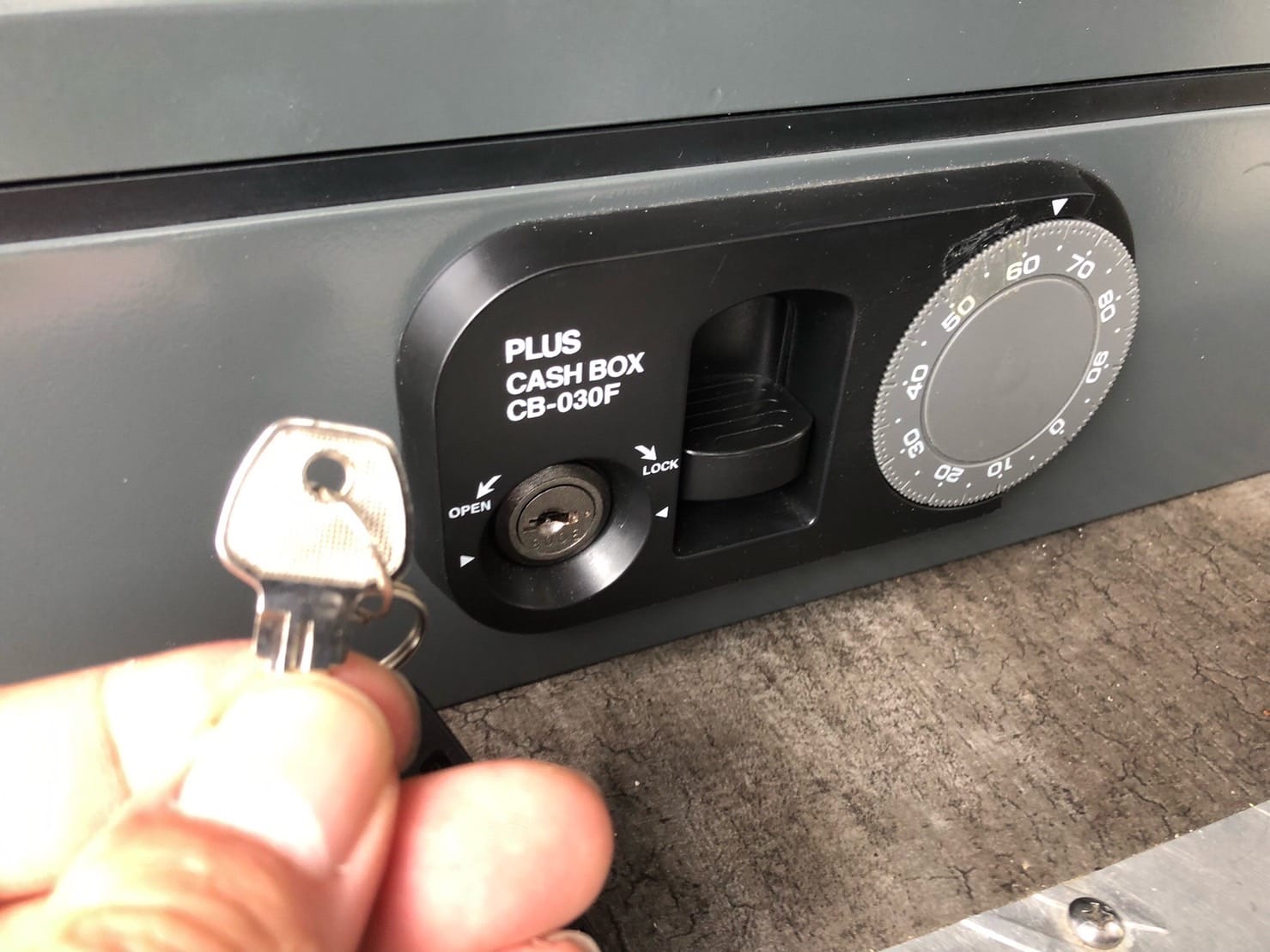 ダイアル錠の前で鍵を持っている