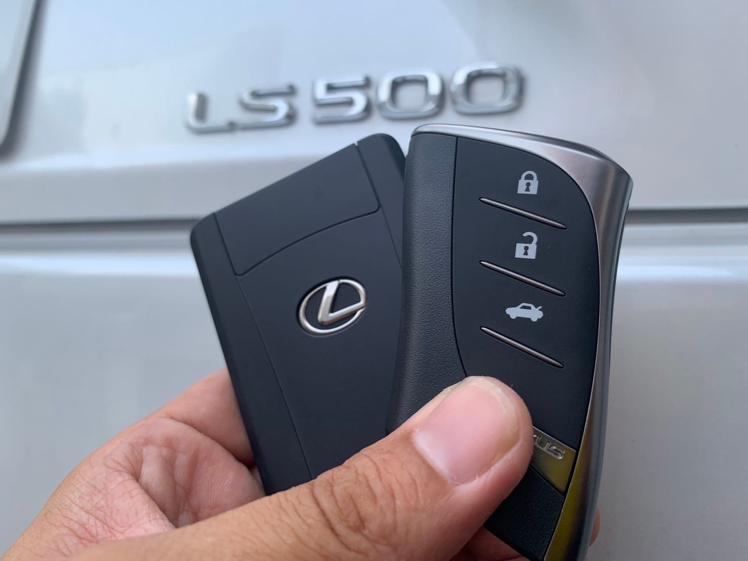 レクサスの既存のスマートキーと新たに作製したスペアキーを手に持っている