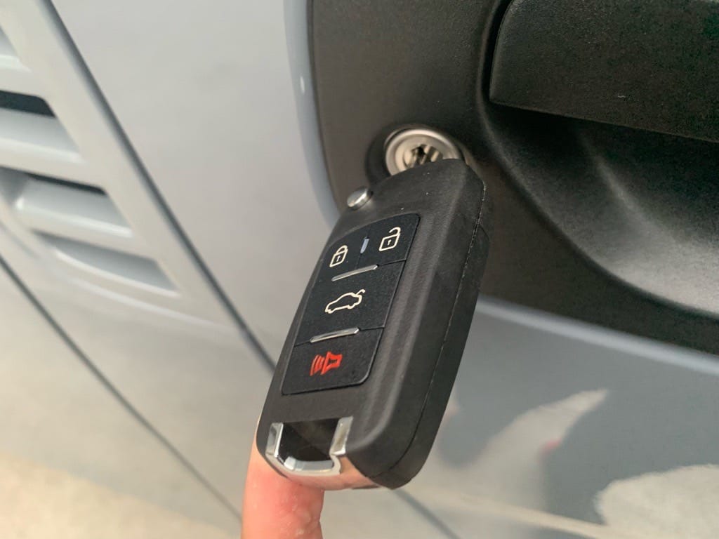 新たに作製した日産キャラバンのキーレスリモコンキーをドアシリンダーに挿している