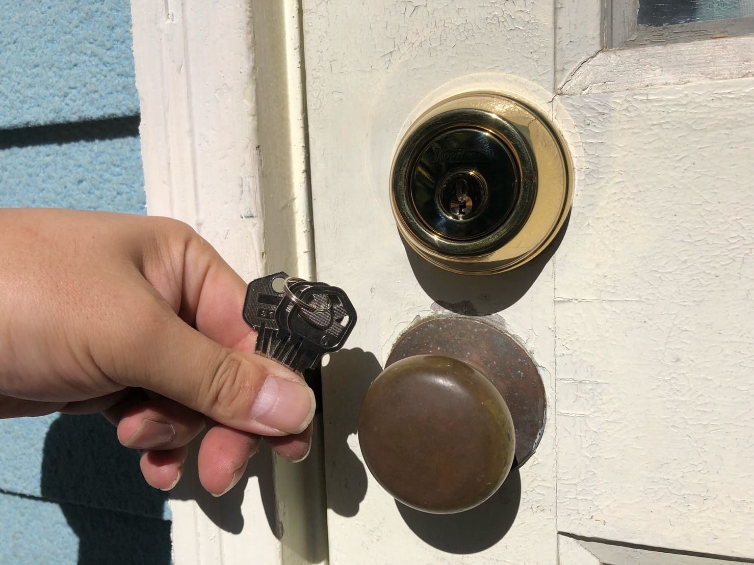 Kwiksetの錠前に交換。鍵穴の前で付属の鍵を手に持っている