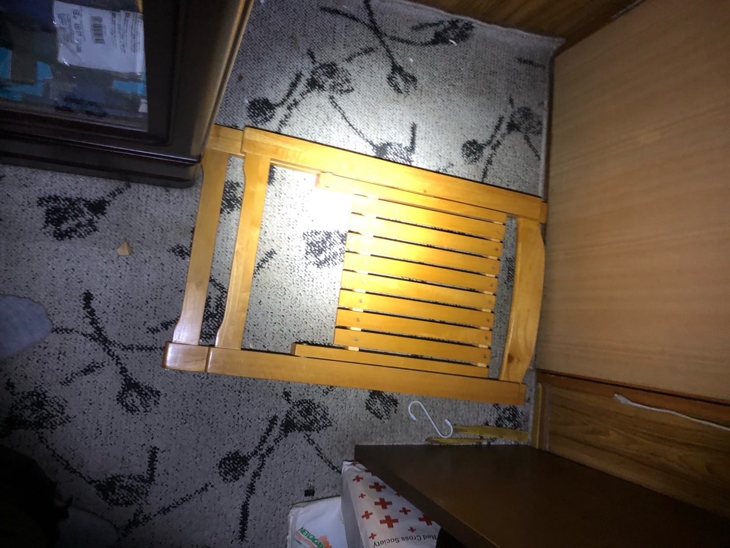 木製の折り畳み椅子が倒れてモノとドアの間にはさまっている