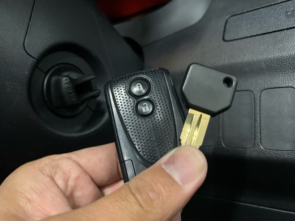 既存のキーフリーリモコンと作製したスペアキ―を手に持っている