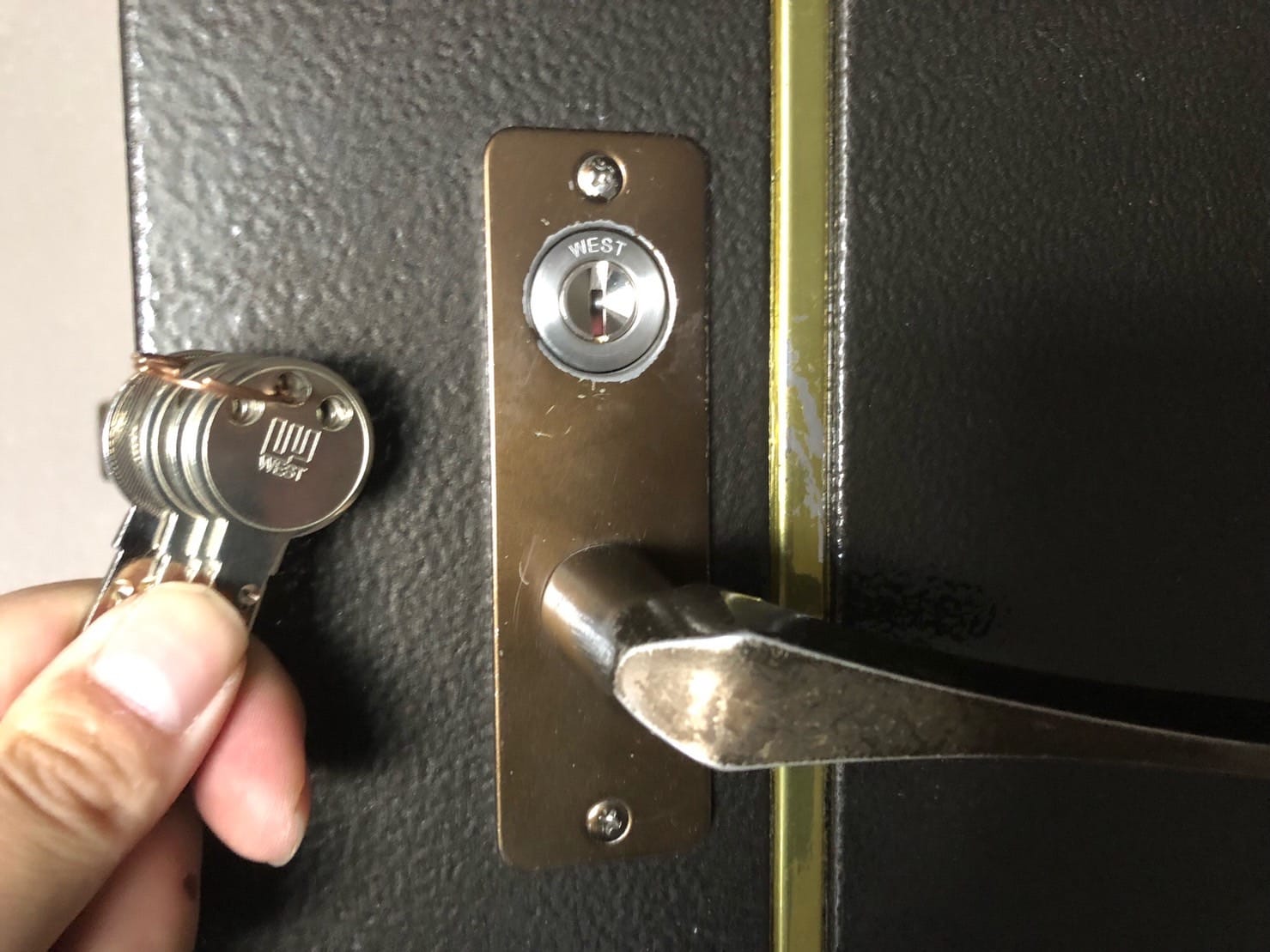 WESTのディンプルシリンダーへ交換。ドアの前で付属の鍵を数本持っている