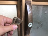 鍵交換完了。錠前の前で付属の鍵を持っている