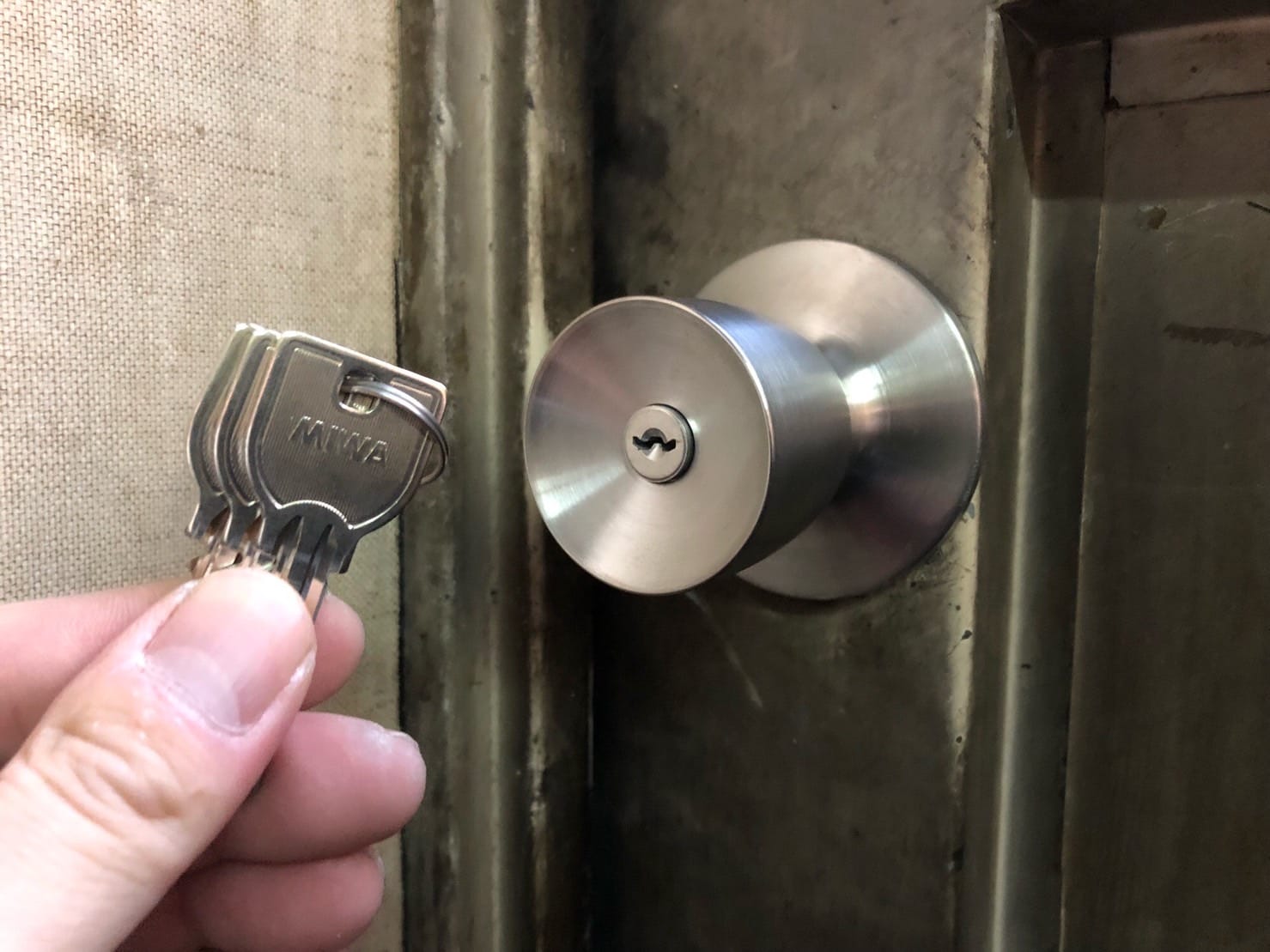 MIWAの錠前へ交換完了。ノブの前で付属の鍵3本を持っている