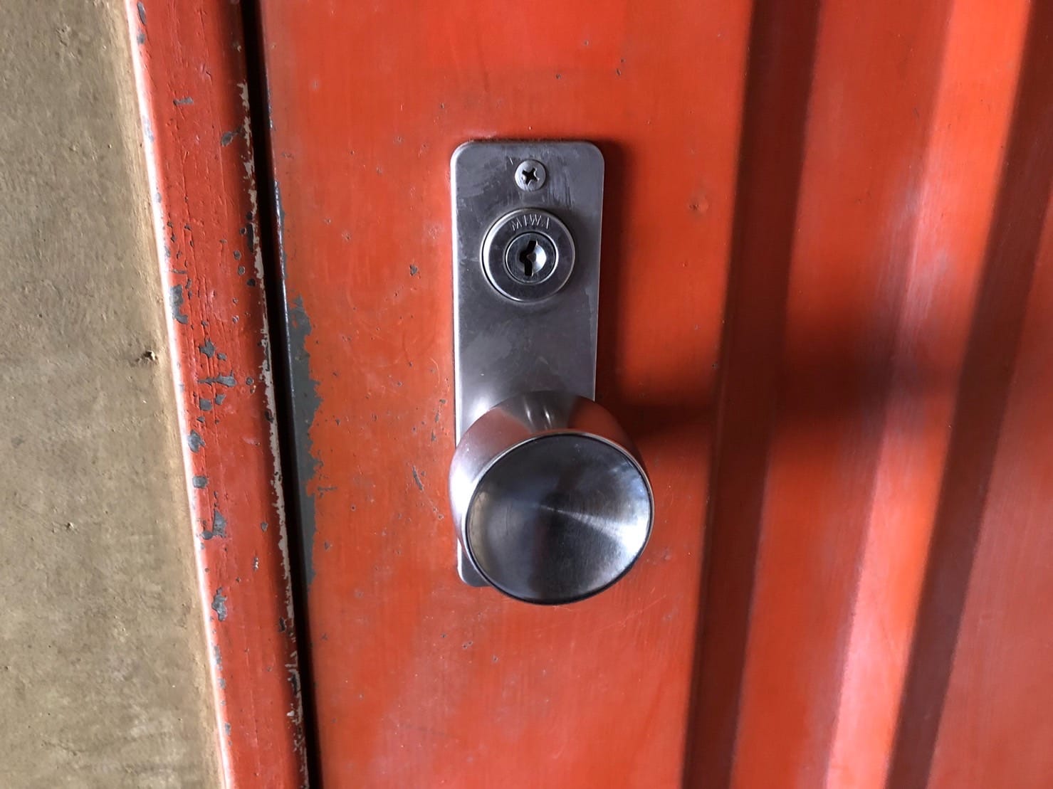 鍵交換を行う赤い扉。MIWAの錠前がついている
