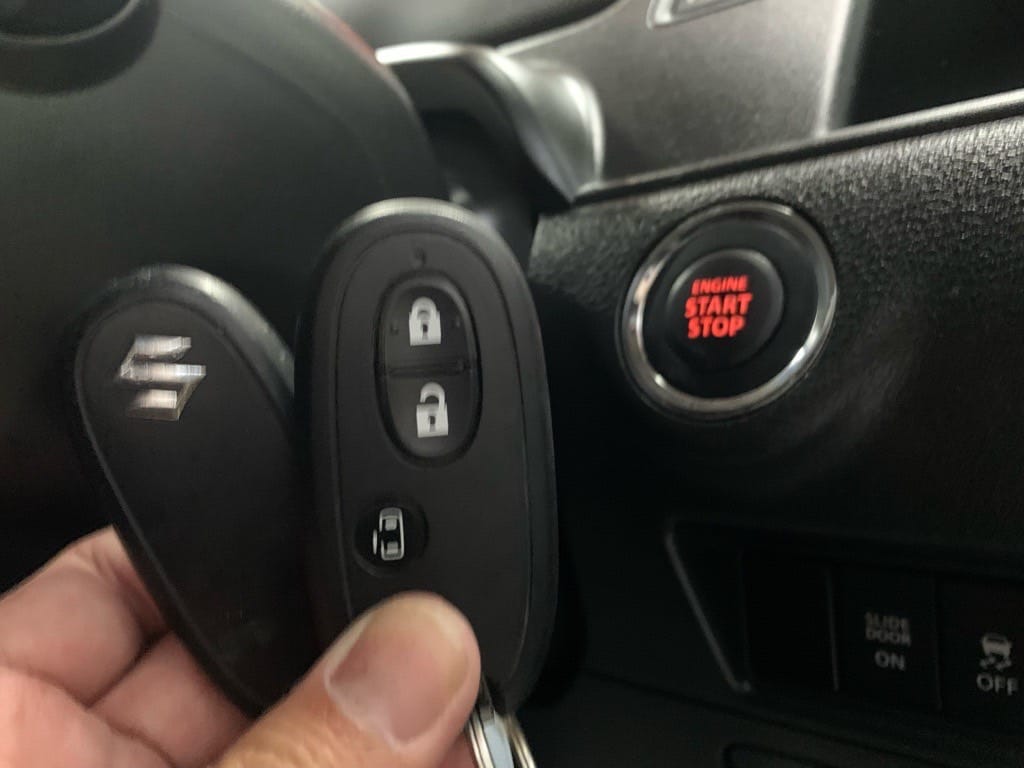 登録が完了したスズキソリオのスマートキーをスタートボタンの前で持っている