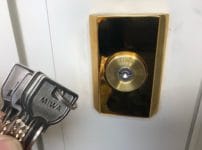 鍵の交換が完了。シリンダーの前で付属の鍵を持っている