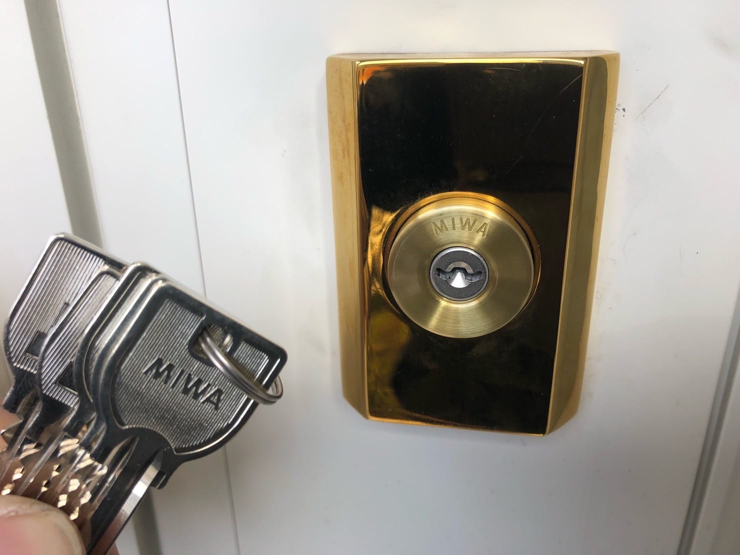 鍵の交換が完了。シリンダーの前で付属の鍵を持っている