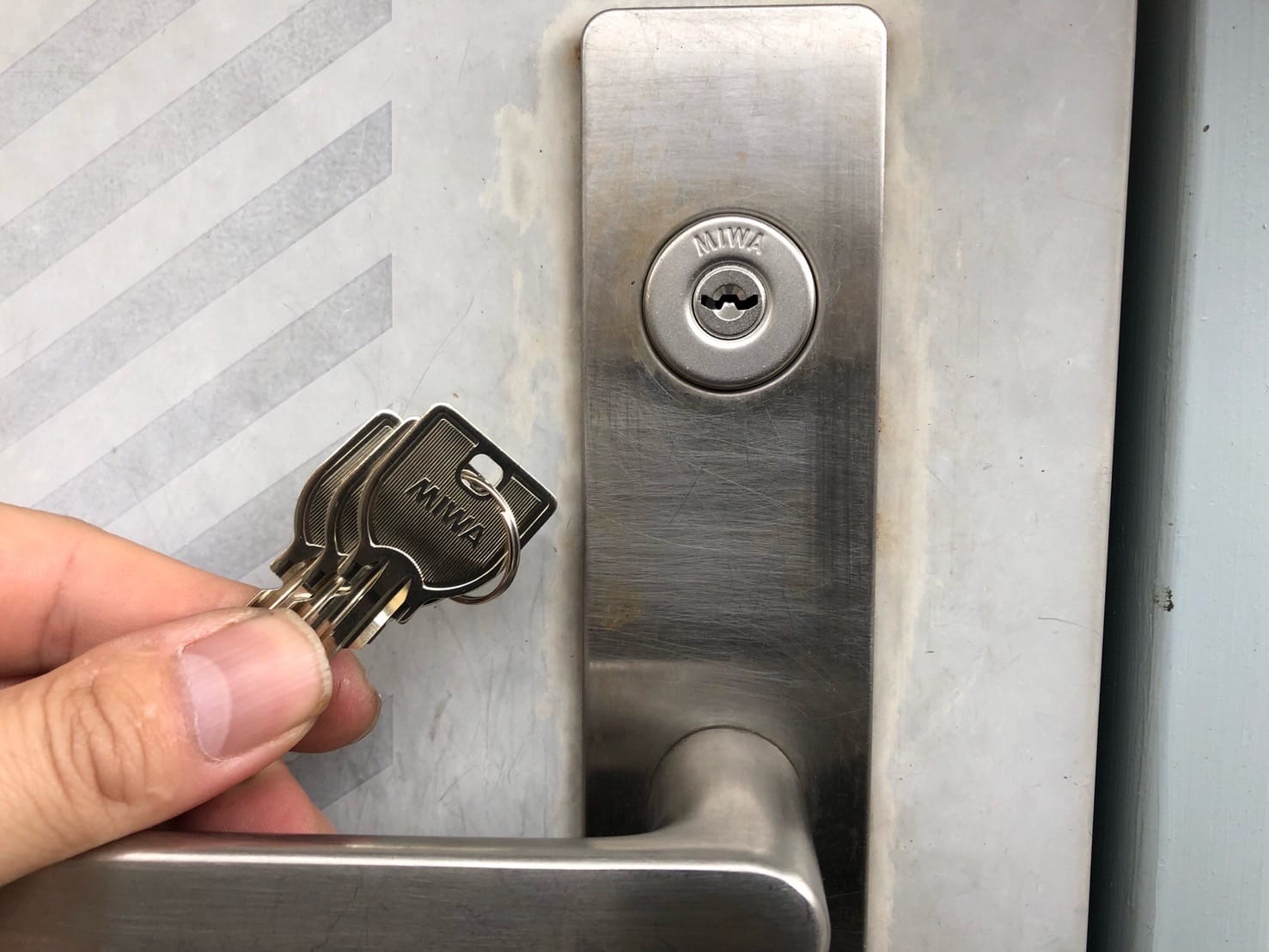 鍵交換が完了。シリンダーの前で付属の鍵３本を持っている