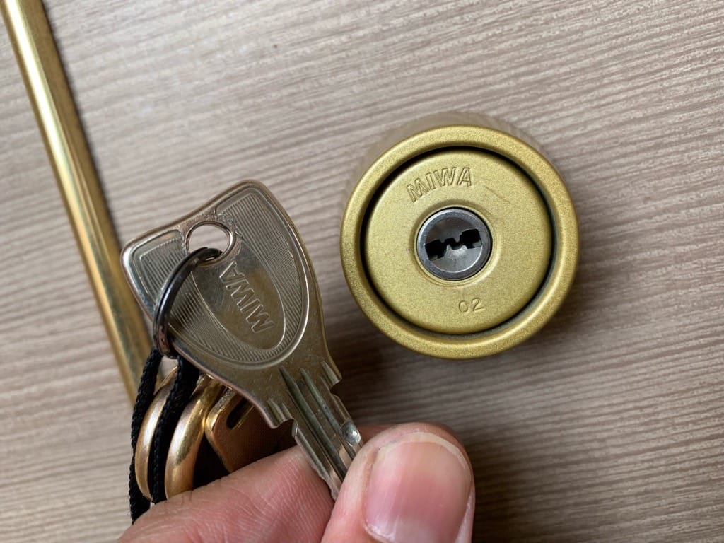扉に再びシリンダーを取り付けました。鍵をシリンダーの前で持っている