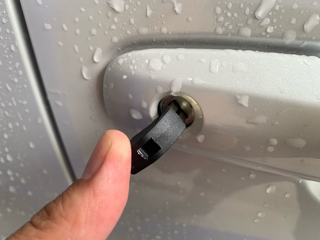 作製したトヨタヤリスクロスのドアキーをドアシリンダーに挿している