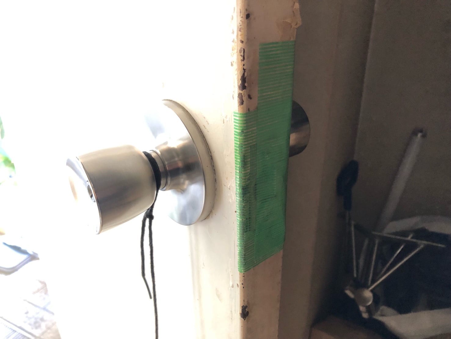 鍵が自動でかからないようにテープが貼られた鉄扉