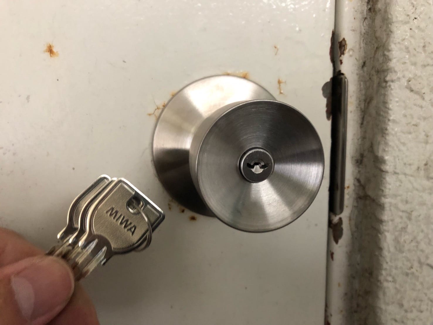 新たな鍵へ交換、ノブの近くで鍵３本持っている