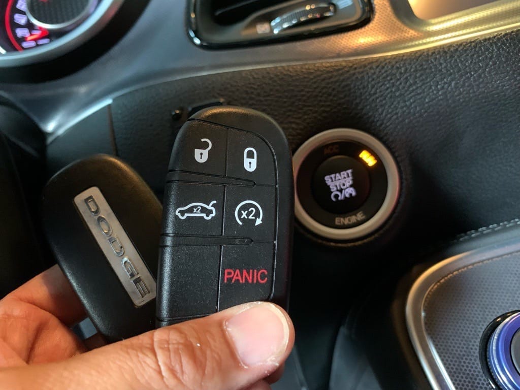 登録が完了したチャレンジャーのスマートキーをスタートボタンの前で持っている