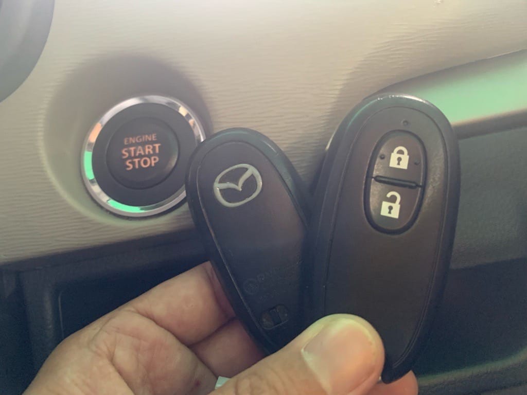 スタートボタンの横で登録が完了したスマートキーを手に持っている様子