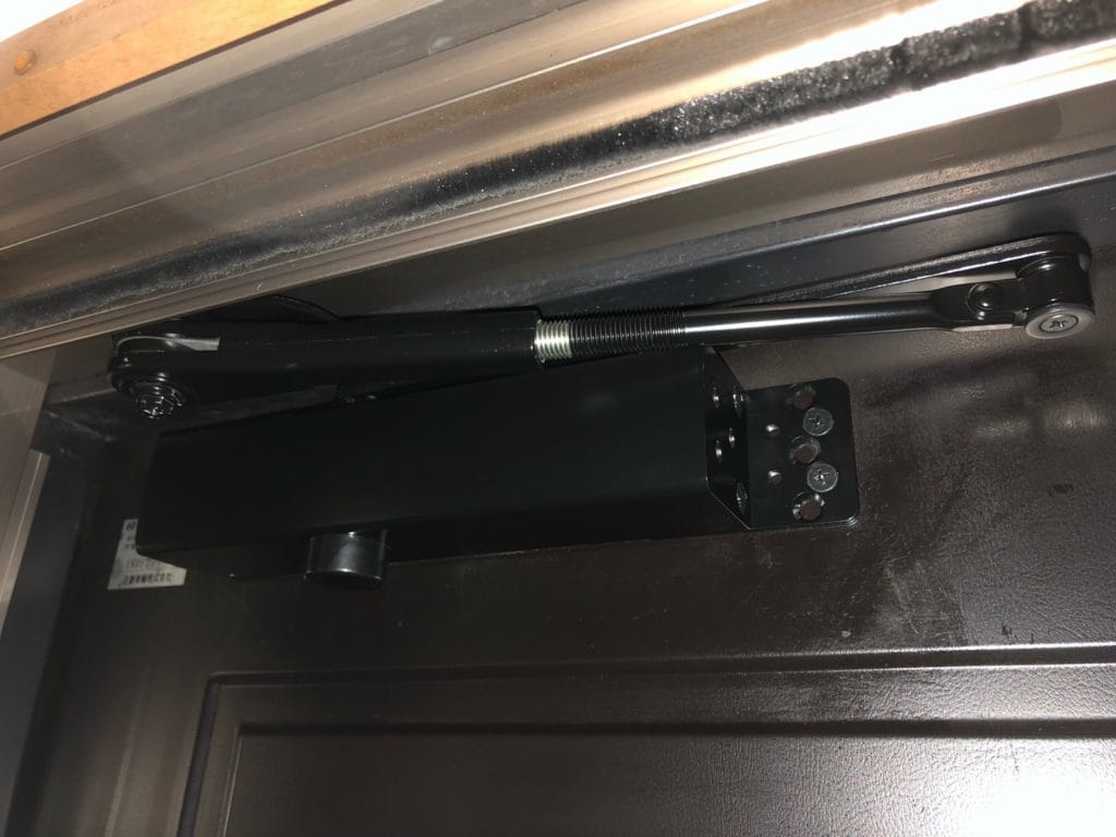 故障していたドアクローザを取り外して新しいドアクローザーを取り付けた状態