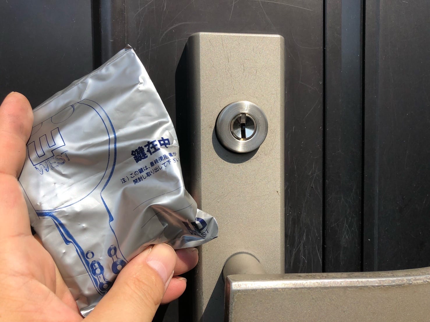 交換した上の鍵の前で付属の鍵を持っている