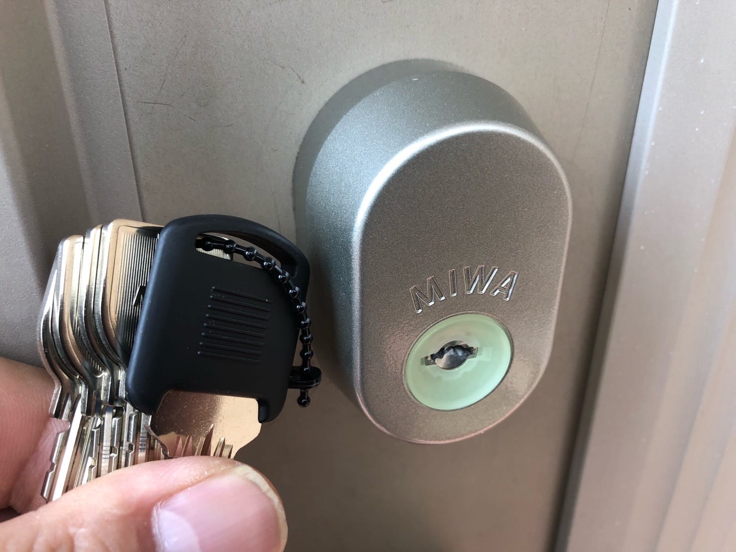 ゴールド色のキーシリンダーからシルバーのキーシリンダーへ交換。付属の鍵を手に持っている
