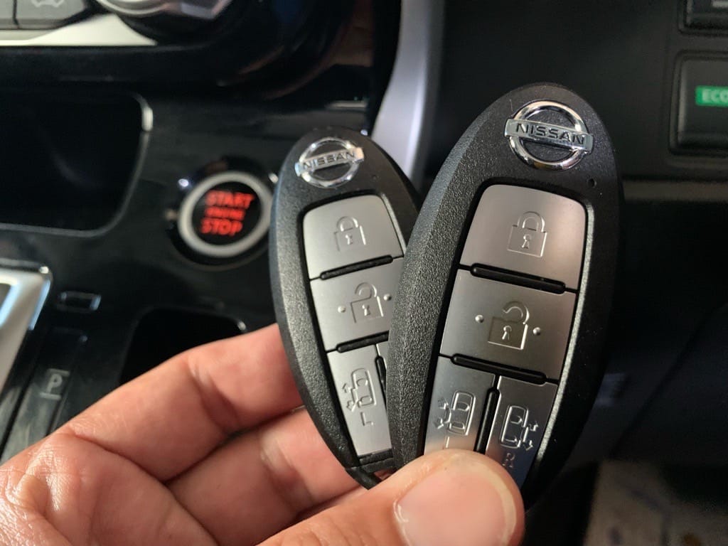 日産セレナの運転席に乗り込みスタートボタンの横でスマートキーのスペアキーを持っている