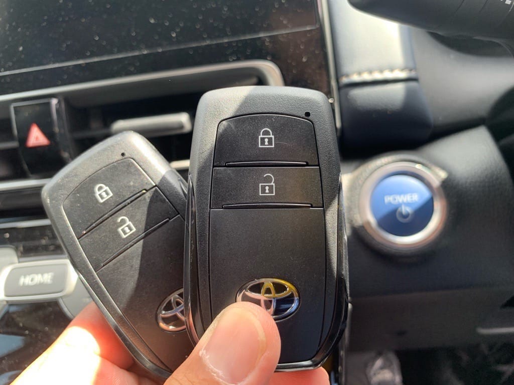 登録したトヨタアクアのスマートキーをスタートボタンの前で手に持っている