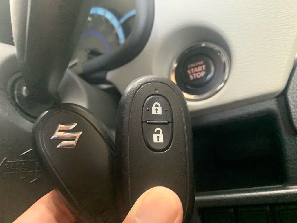 鍵登録が完了したスズキワゴンRのスマートキーをスタートボタンの前で手に持っている