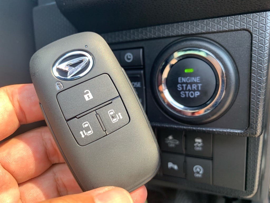 登録が完了したダイハツタントのスマートキーをスタートボタンの前で手に持っている