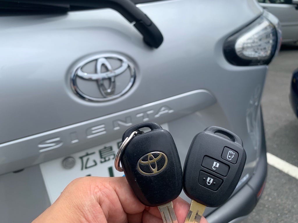 作製したリモコンキーと既存キーを手に持っている