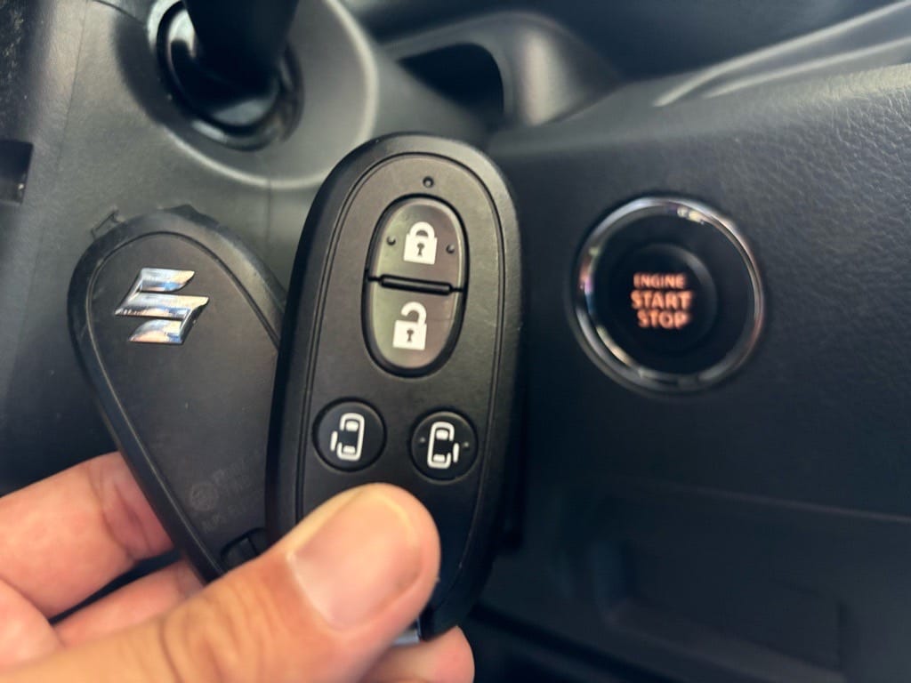 登録が完了したスズキスペーシアのスマートキーをスタートボタンの前で持っている