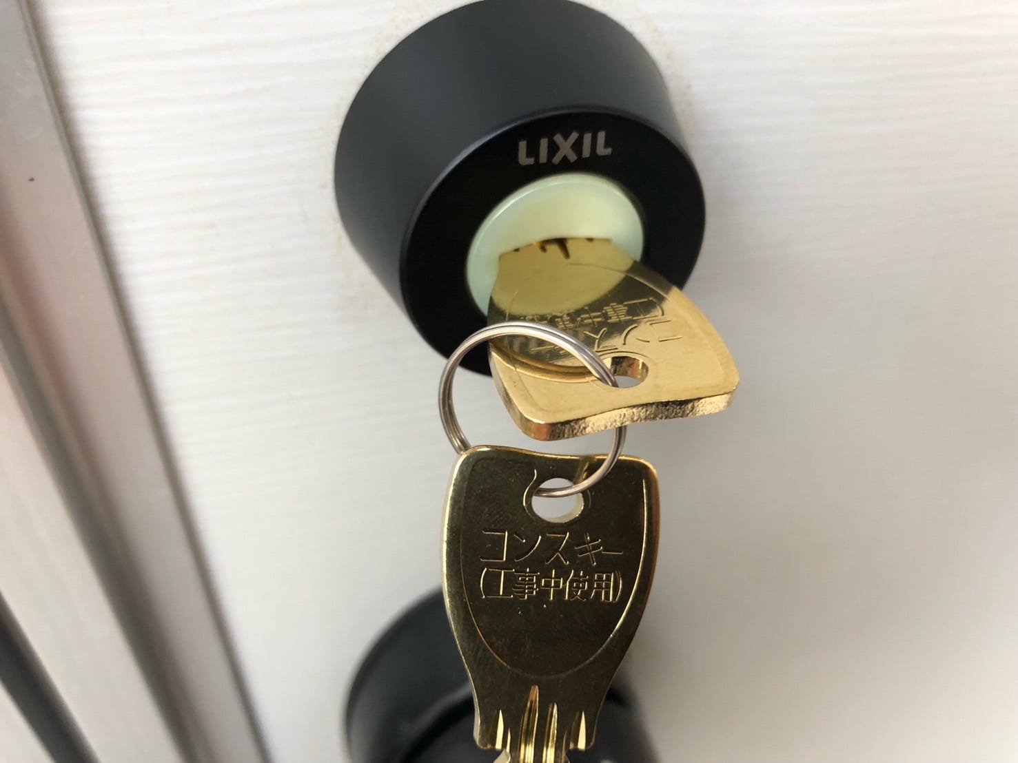 交換したキーシリンダーに鍵を挿している
