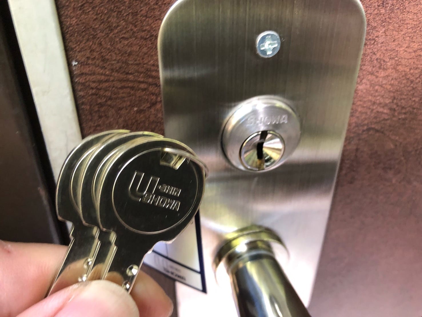 交換が完了した鍵の前で付属の鍵を持っている