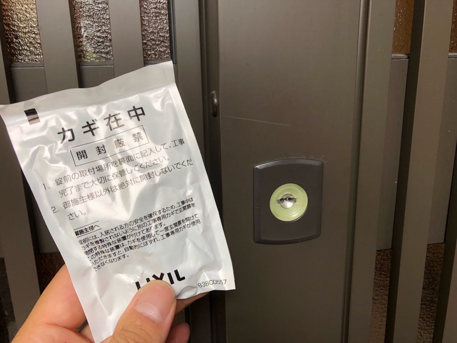 新たに取り付けたシリンダーと付属の鍵を手に持っている