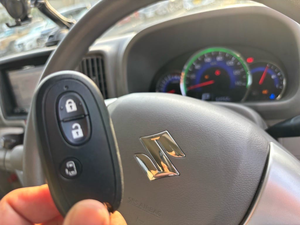 登録が完了したスズキエブリィのスマートキーをステアリングの前で持っている