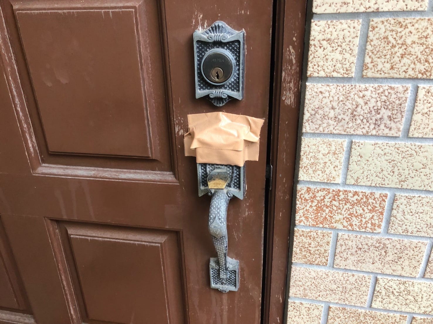 ガムテープが貼られた玄関ドア