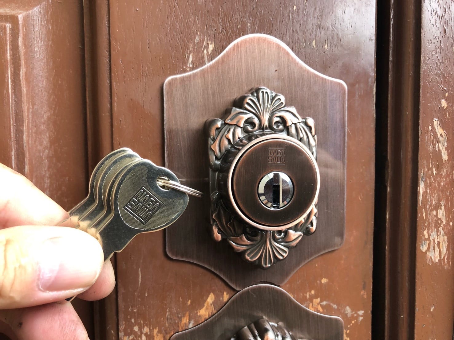 ディンプルシリンダーへ交換、取り付けたシリンダーの前で付属の鍵3本を持っている