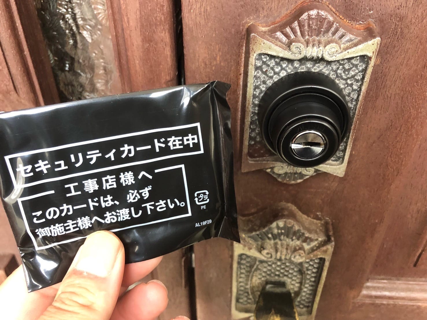 FBロックキーシリンダーへ交換、セキュリティカードが入った袋を持っている