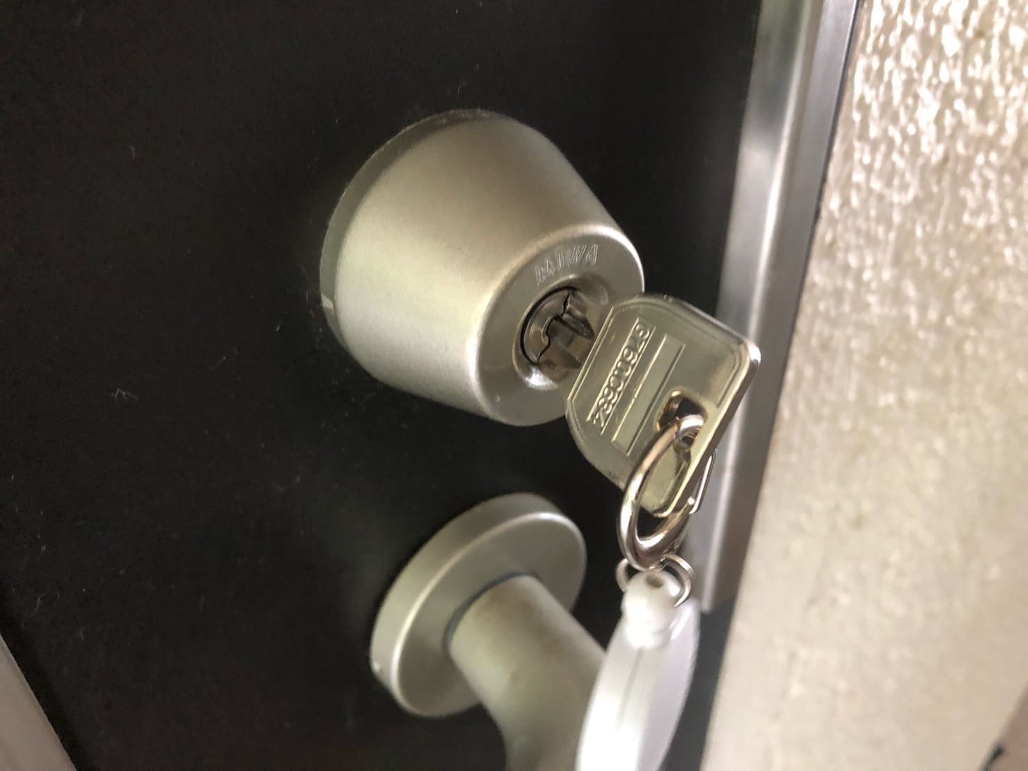 玄関ドアのキーシリンダーに鍵がささっている