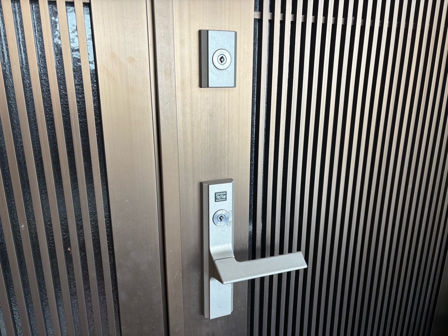 鍵交換を行う玄関ドア。TOSTEMの2ロックレバーハンドル錠にディスクシリンダーが付いている