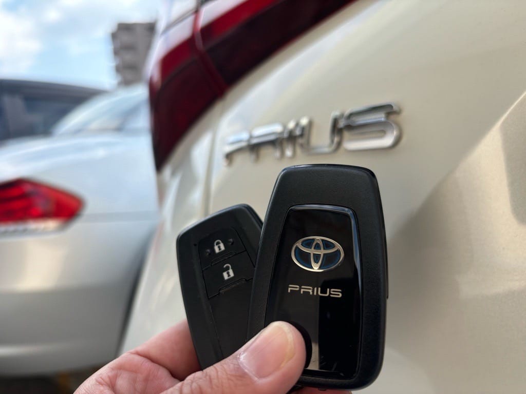 プリウスのスマートキー2個を手に持っている