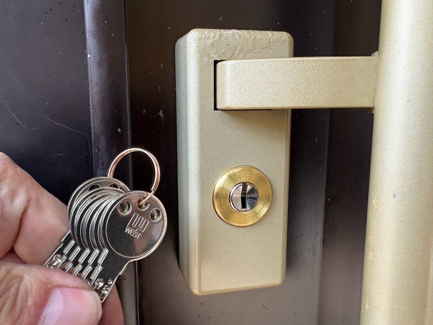 交換、取付完了。WEST社のディンプルシリンダーへ交換しました。交換したシリンダーの前で付属の鍵を持っている