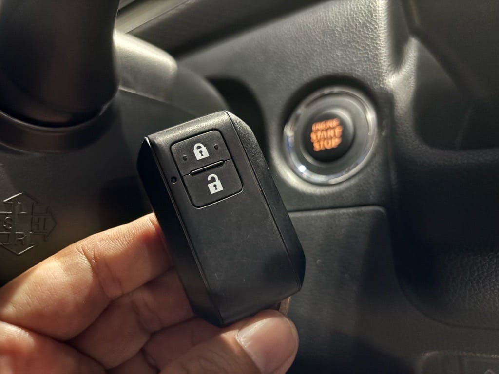 スマートキー登録が完了。ワゴンRのスタートボタンの前でスマートキーを持っている