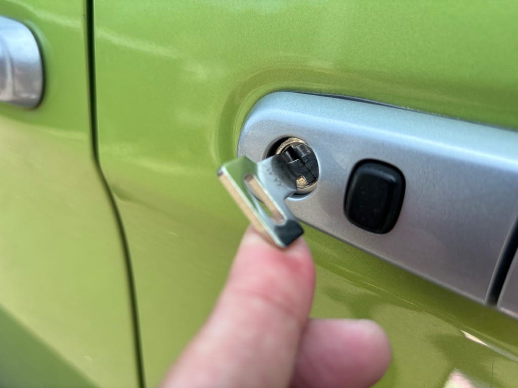 作製したメカニカルキーをルーミーのドアシリンダーにさしている