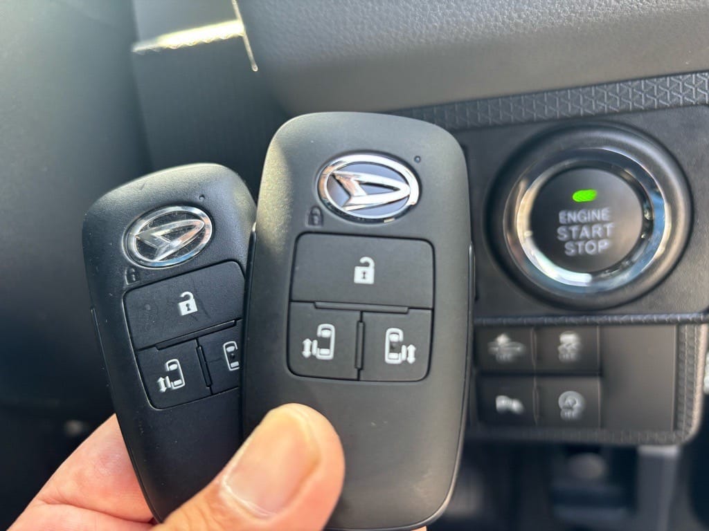 登録が完了したタントのキーフリーリモコン2個をスタートボタンの前で持っている