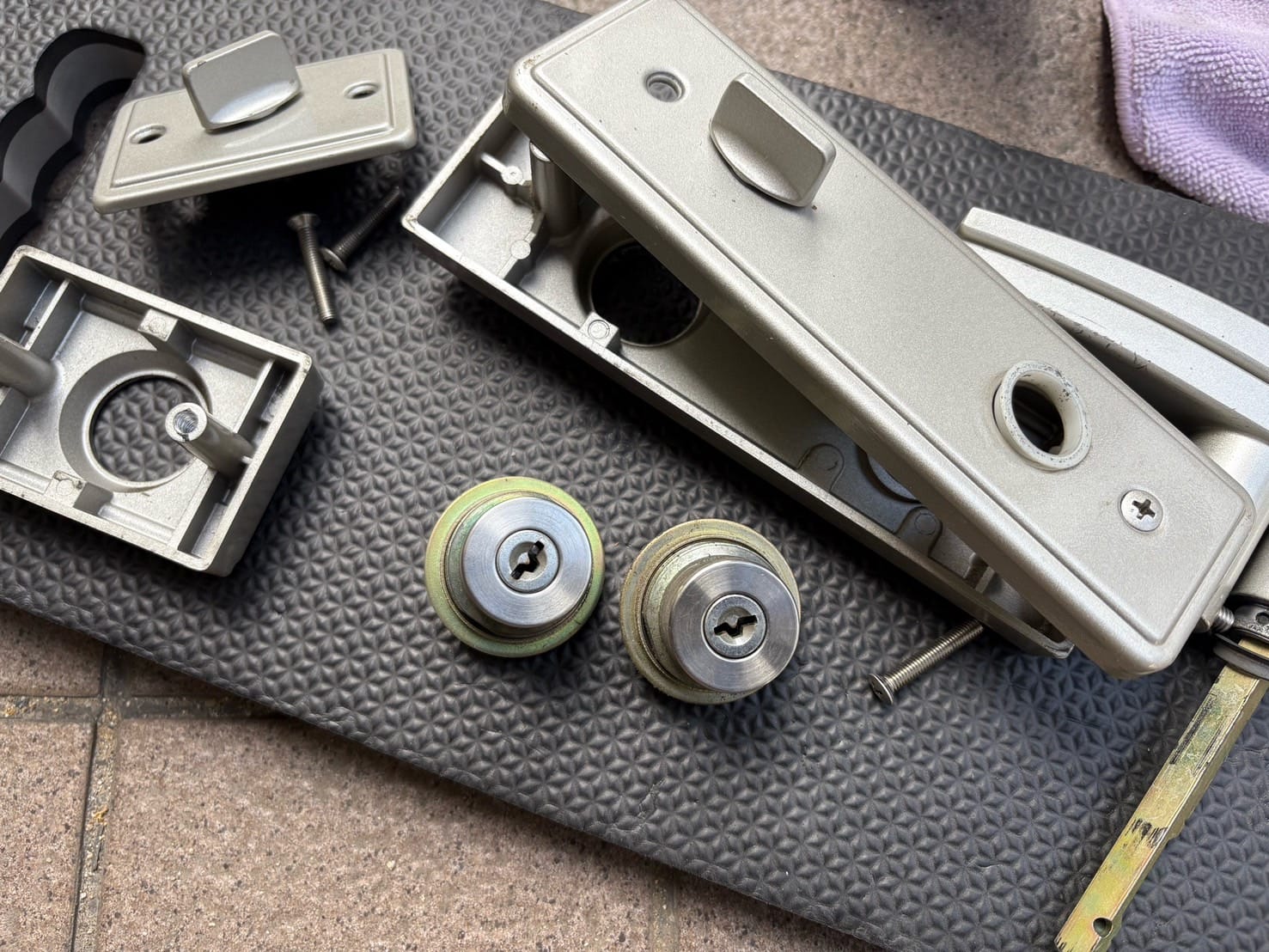 取り外した錠前、交換前のディスクシリンダーとディンプルシリンダー