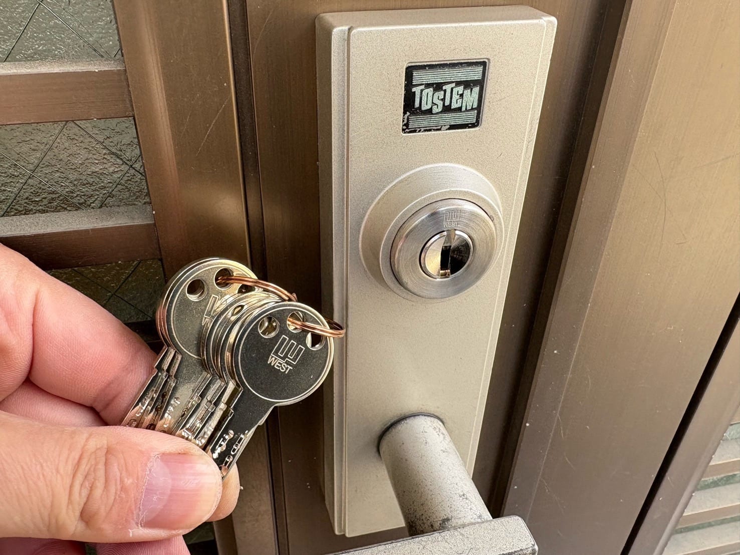 ディンプルキーへ交換完了。ドアの近くで付属の鍵を数本持っている