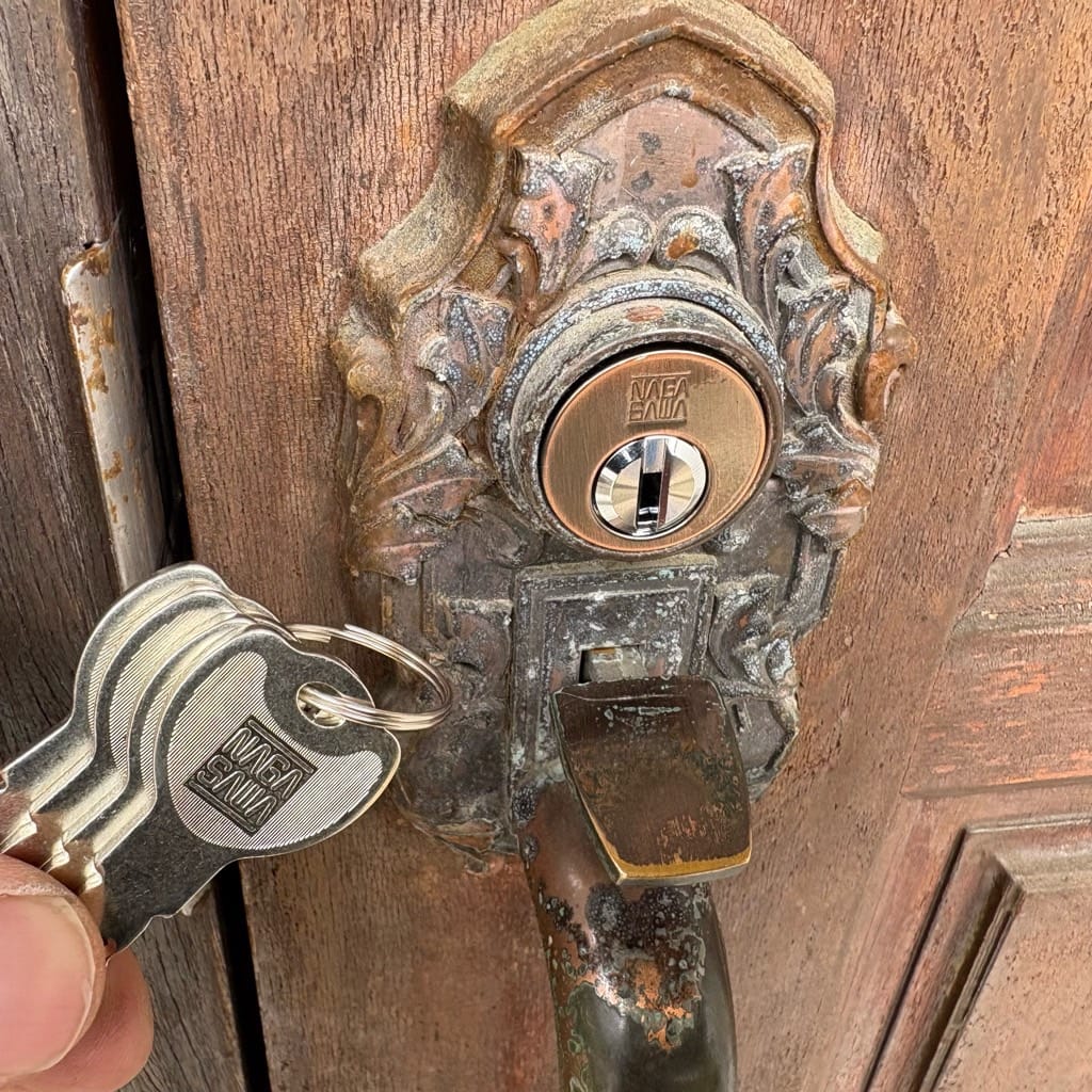 交換後の扉の近くで付属の鍵数本を持っている